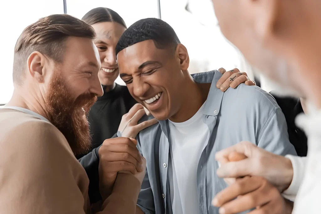 Group of men smiling and supporting each other during addiction recovery, symbolizing friendship and positive change at Alcohol Detox London.