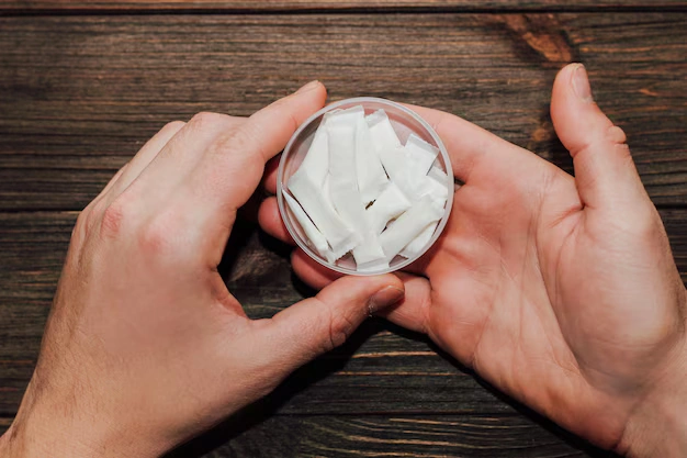 A person holding white nicotine pouches, highlighting substance misuse risks and the need for professional detox support in London.