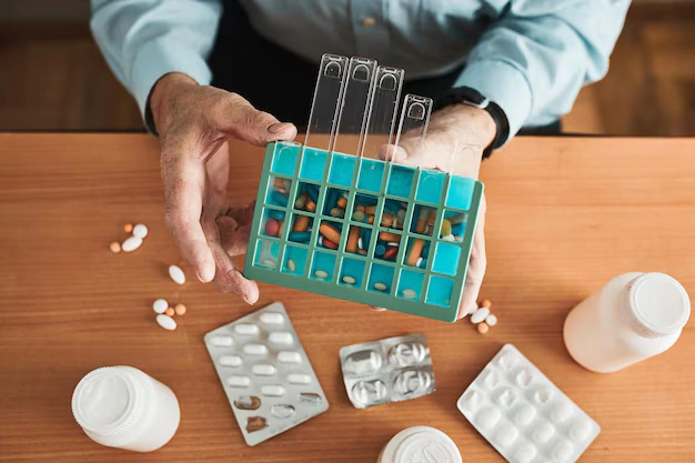 An older man sorting multiple pills, reflecting substance dependence concerns and the importance of safe detox services in London.